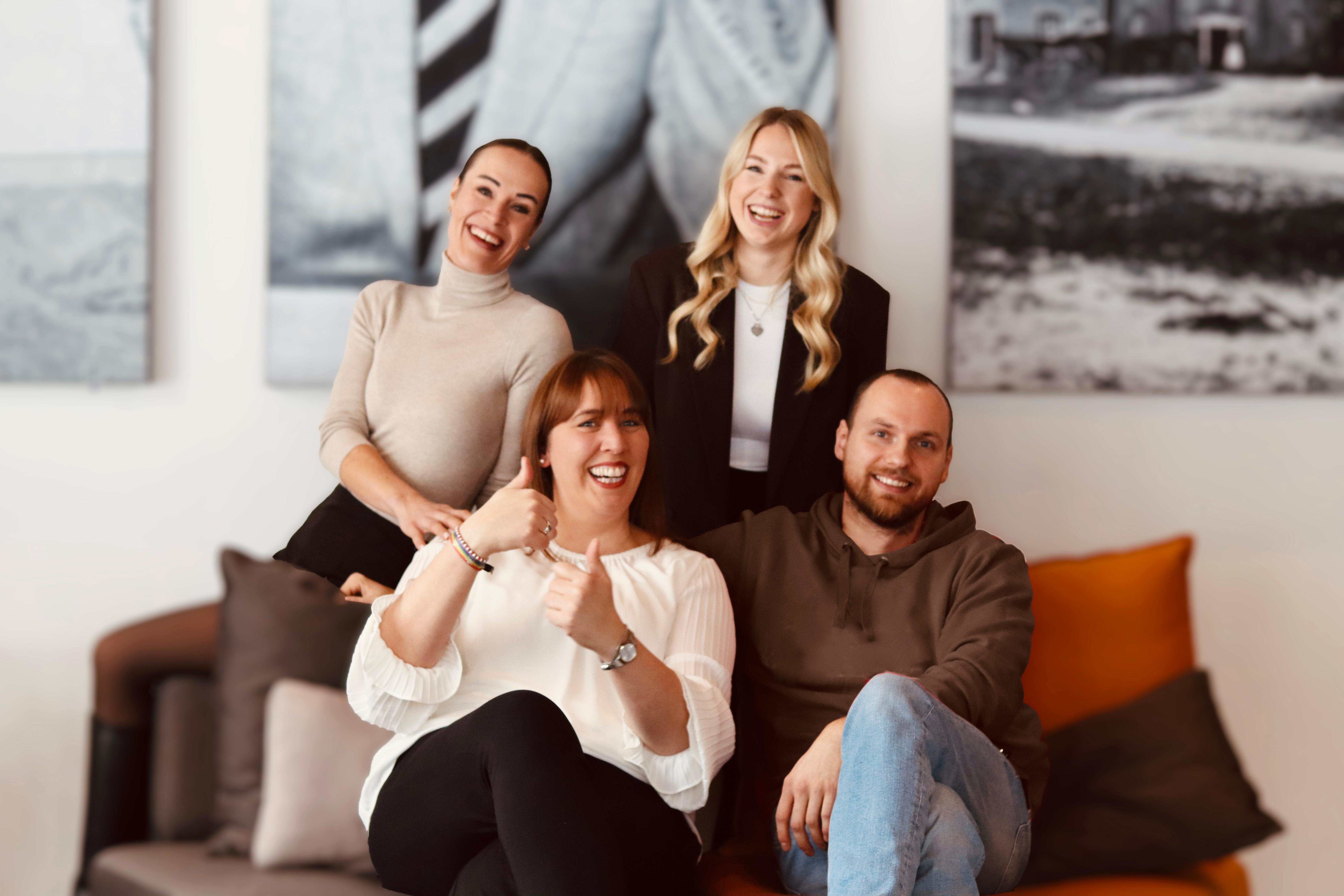 Vier Ausbilder von LOBO HOME sitzen gemeinsam in einem Aufenthaltsbereich und lächeln in die Kamera