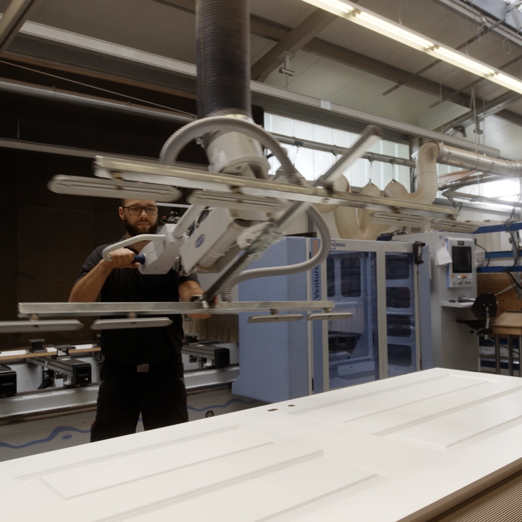 Mitarbeiter in der hauseigenen Produktion von LOBO HOME bei der Bearbeitung einer weißen Innentür