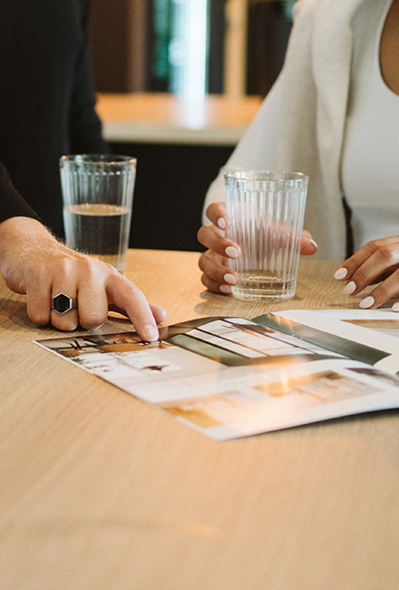 Personen besprechen Bildmaterial und Gestaltungsideen an einem Tisch
